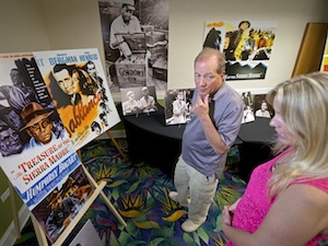 Stephen Bogart, left, son of Humphrey Bogart and Lauren Bacall, peruses posters and other memorabilia highlighting his father's legendary cinema career with Suzanne Holmquist, who runs tours on the African Queen. Image: Andy Newman